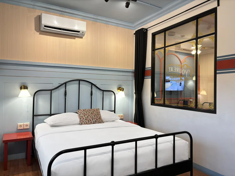London: Air conditioning is in every bedroom, including this one with a classic iron bed frame.