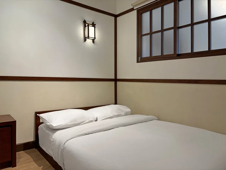 Okinawa: A bedroom with its own air conditioner and a small side table.