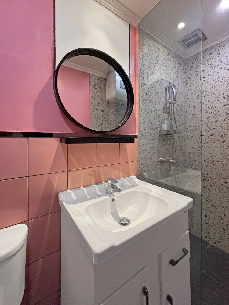 Myeong-dong: Pink-tiled bathroom with a hot-water shower.