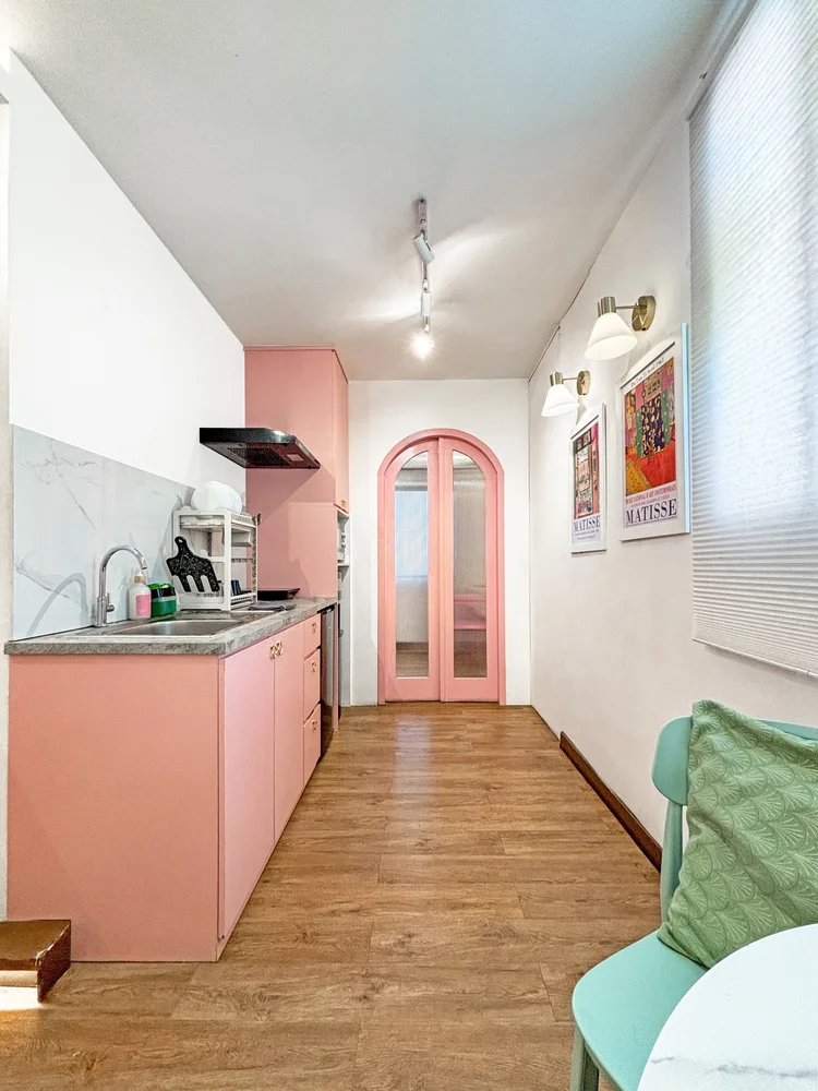 Milan: The galley kitchen along the hall, the pink arched door into the bedroom.