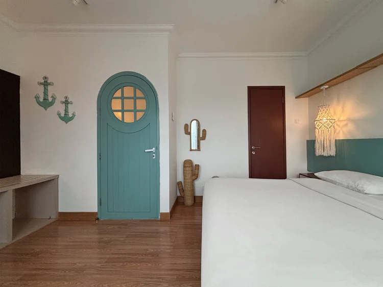 Mykonos: The master bedroom with its blue porthole door, shelf and mirror, island style right into the bedroom.