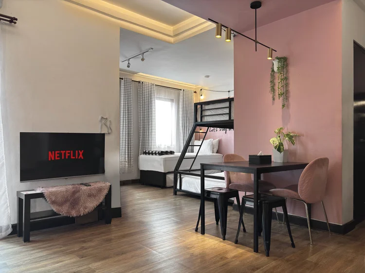 Myeong-dong: TV with Netflix and a four-person dining table with pink chairs.