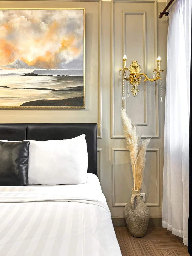 Vienna: Detail of the painting and gold sconces above the headboard, with a pampas grass vase.