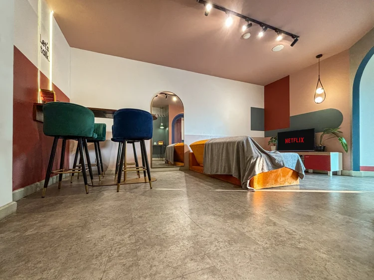 Geneva: A bar table with high stools, in the same open space as the bed at the far end.