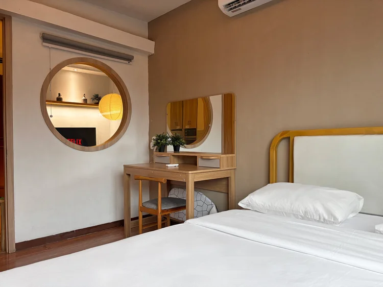Nagoya: A dressing table with mirror and a round window onto the living room.