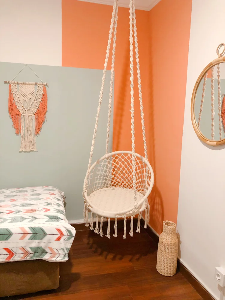 Havana: A reading nook with a rattan swing chair and macrame decor, in the second bedroom.