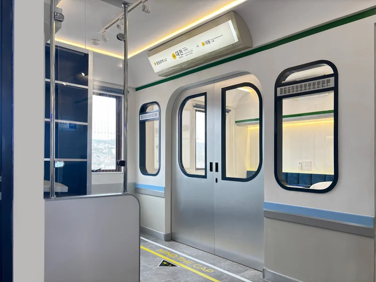 Dae Jeon: A large mirror and window near the subway-style doors.