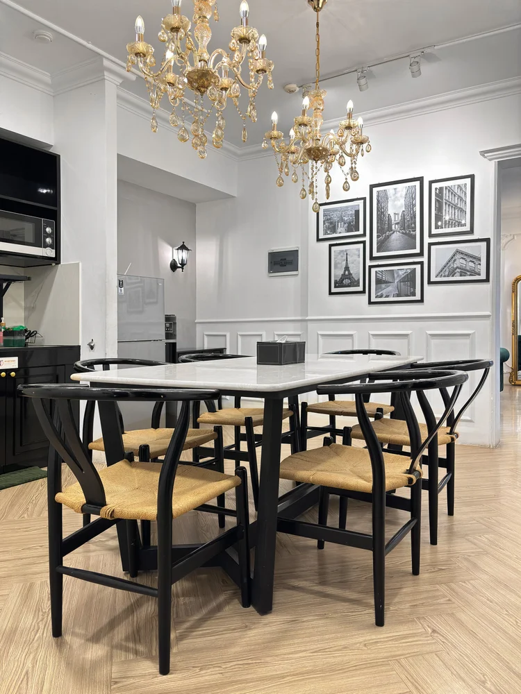 Paris: A dining table for six under the chandelier, the kitchen beside it.