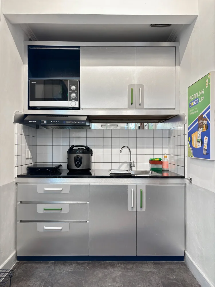 Dae Jeon: Kitchen with a microwave and train-style metal cabinets; the lobby convenience store sells the basics for cooking.