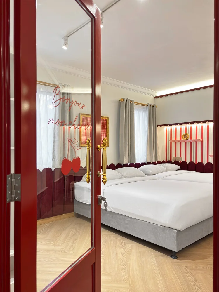 Chamonix: A red French-style door opens to the bedroom, with a mirror beside it.
