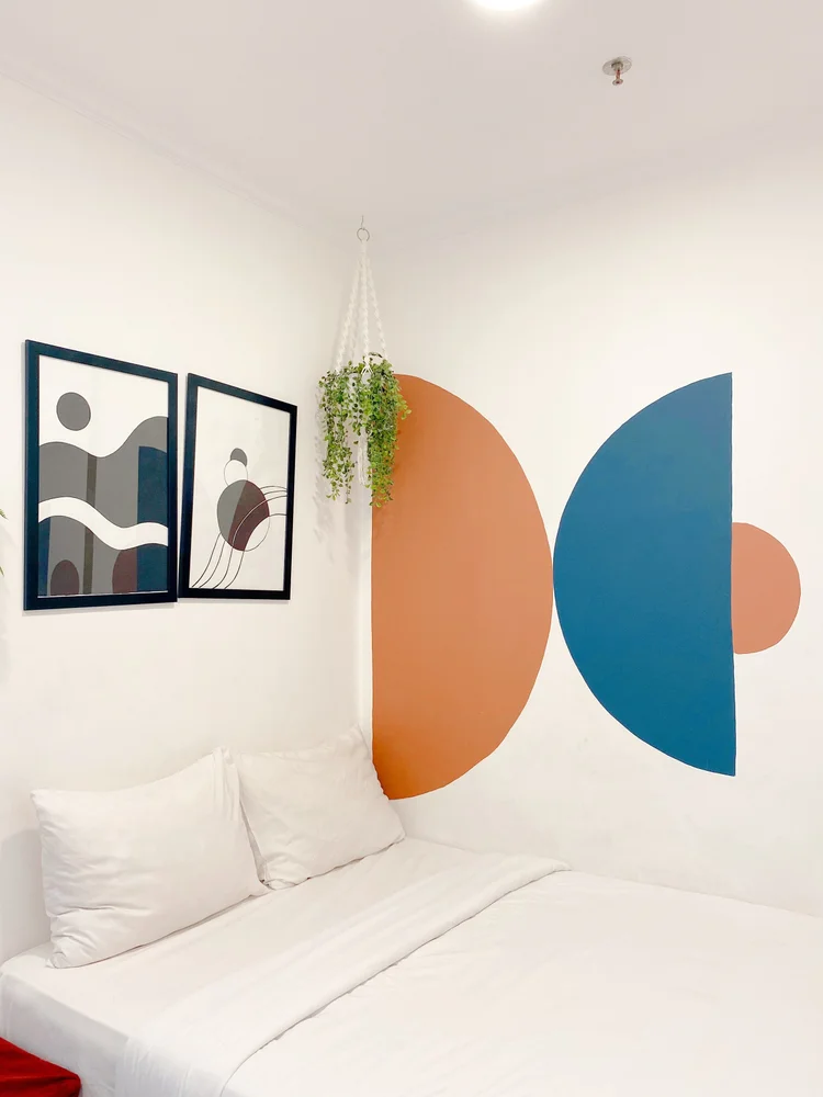 Palermo: Bedroom with a 140 cm small double and an orange-and-blue geometric mural.