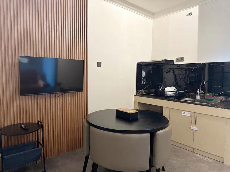 Boston: Smart TV on the timber-slat wall, round dining table right by the kitchen.