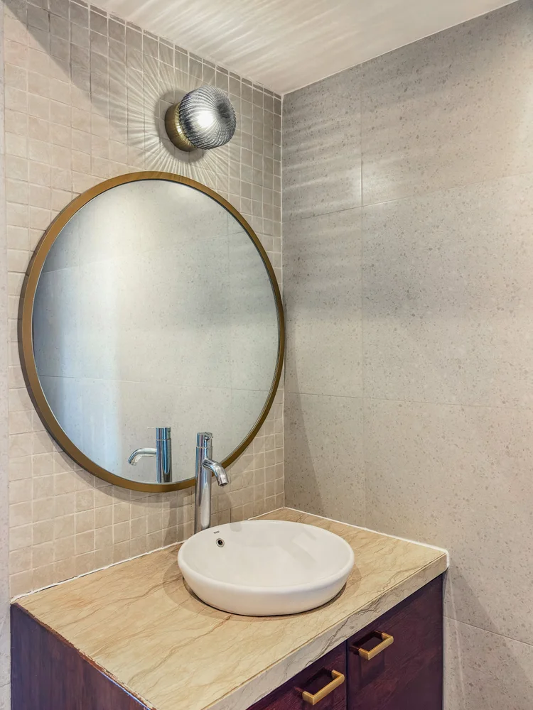 Kensington: A vessel sink and round mirror in the bathroom, a detail touch in every corner of Kensington.
