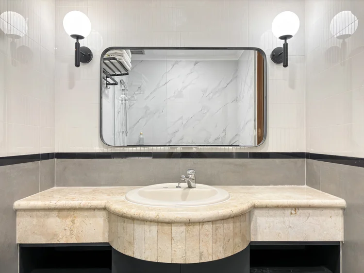 Norfolk: A marble basin with wide mirror and wall lights; clean towels for every guest.