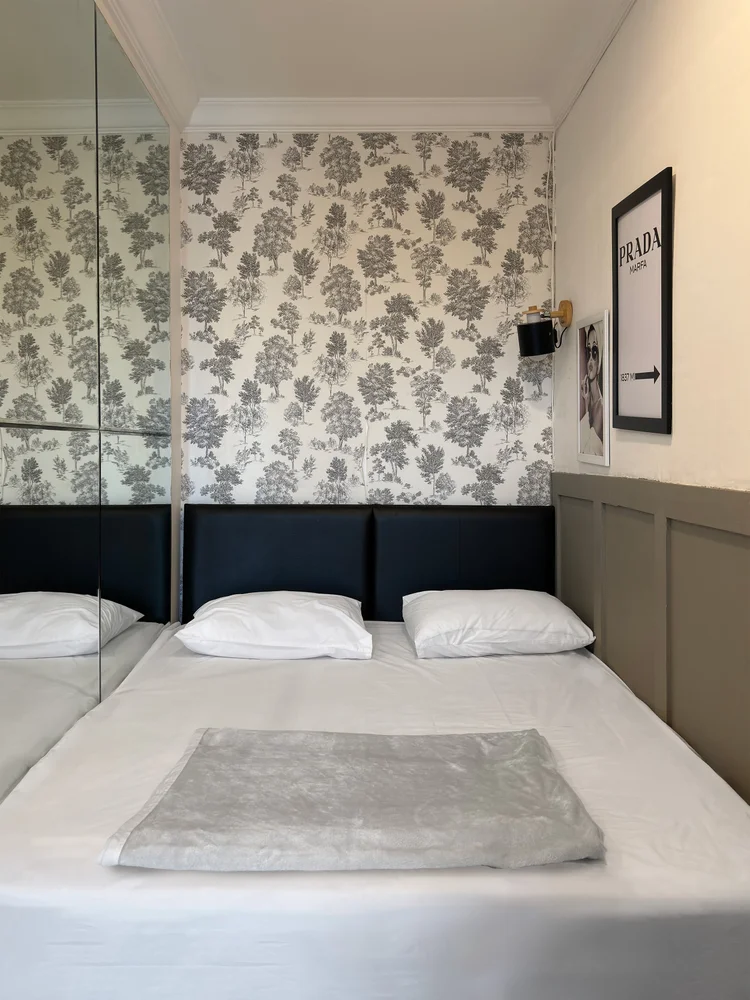 Florence: Master bedroom with floral wallpaper and white sheets, the same standard in all our units.