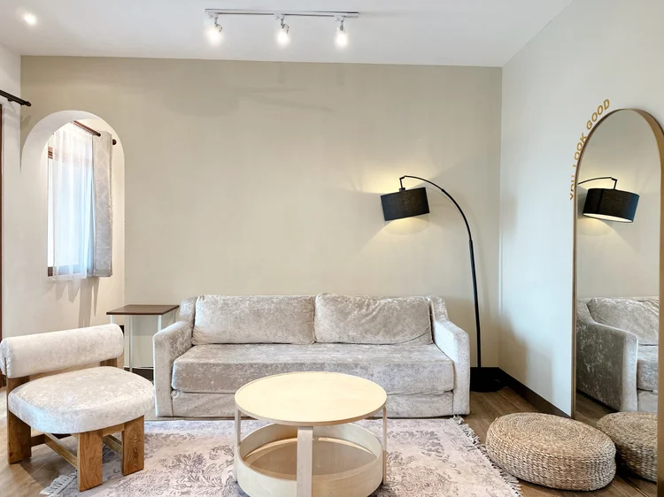 Positano: A hygge living room: folding sofa bed and arched mirror. Sleeps 7, up to 10 with extra beds.