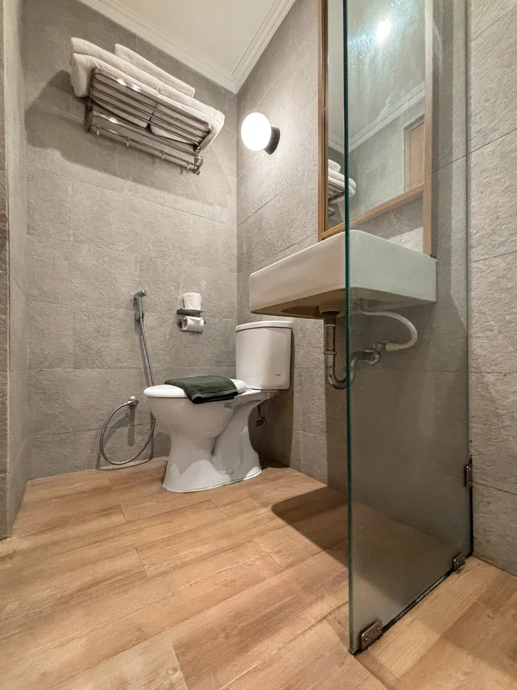 Sapporo: Modern bathroom with a glass-walled shower and toilet.