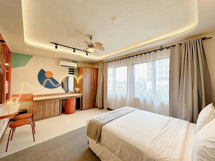 New York: Dressing table, wardrobe and a wide window beside the bed.