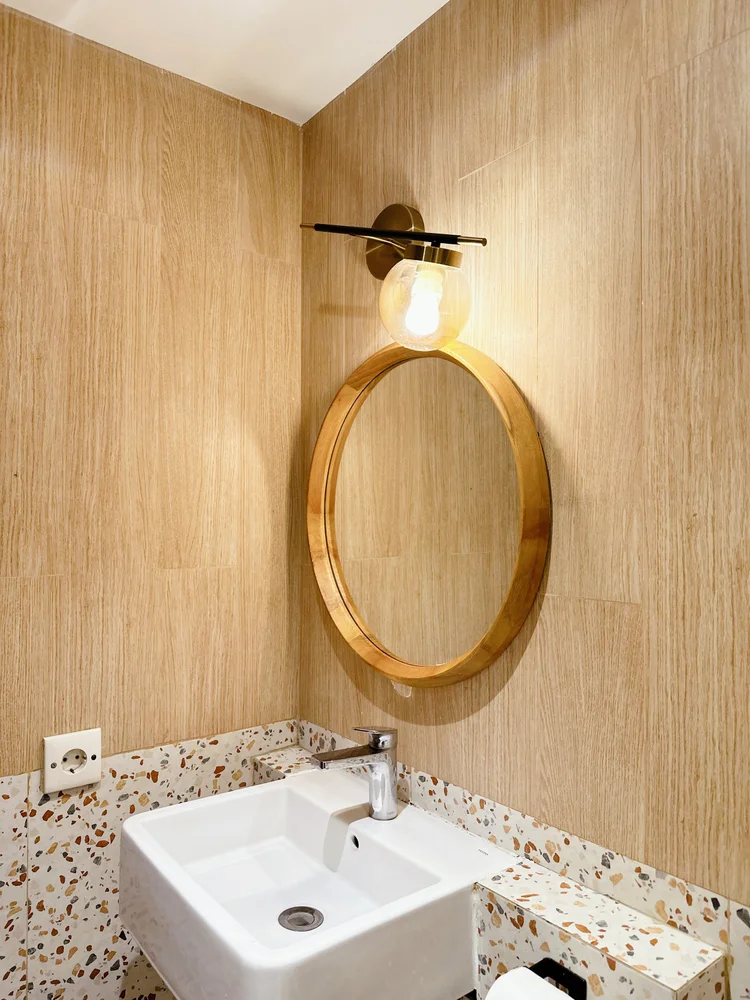 Positano: A round gold mirror over the basin, details right down to the bathroom.