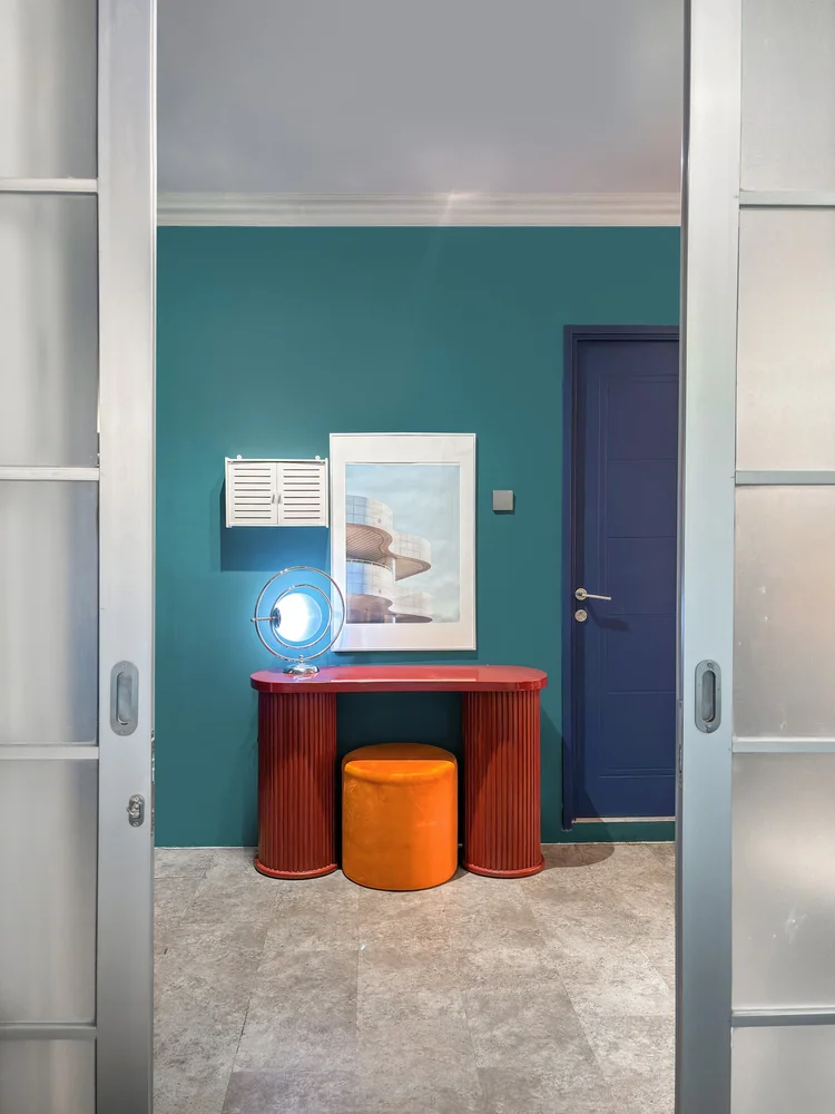 Vancouver: A teal-walled bedroom, with a dressing table and its own AC.