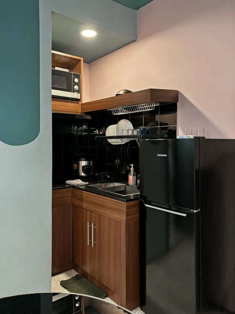 Montreal: Open kitchen with microwave, fridge and dish rack.