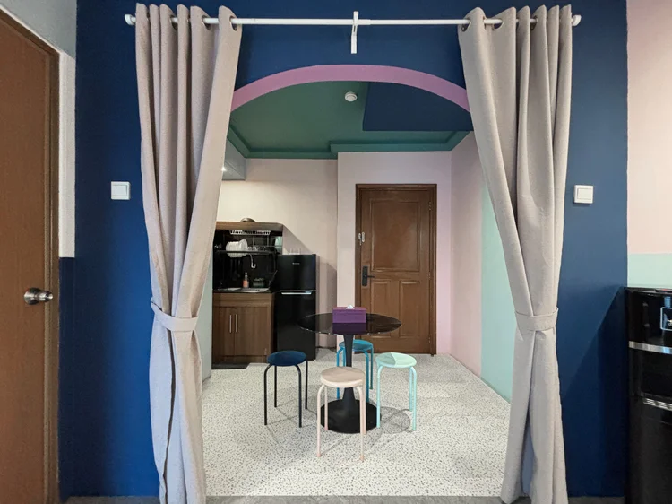 Montreal: A round dining table for four with stools, the fridge in the corner.