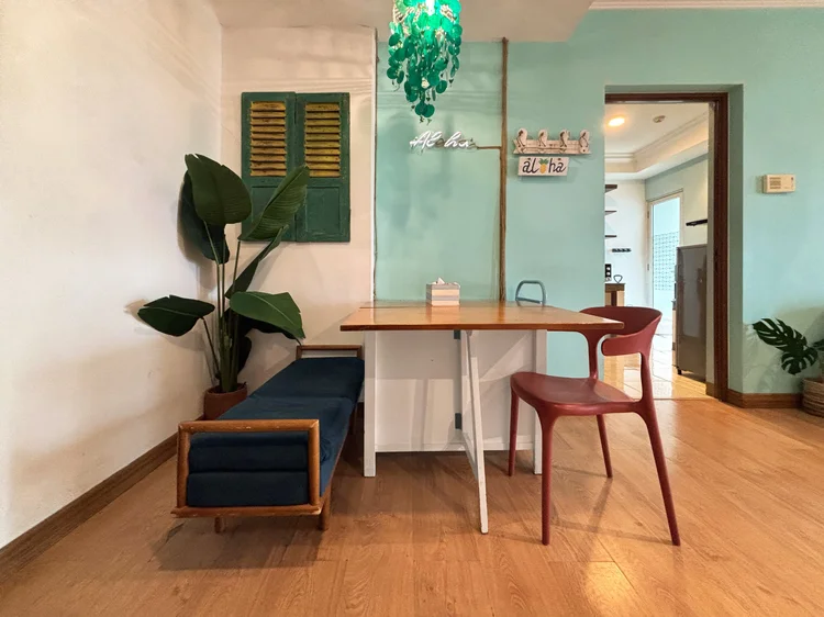 Honolulu: Dining table with a bench and chairs, tropical green shutters beside it.