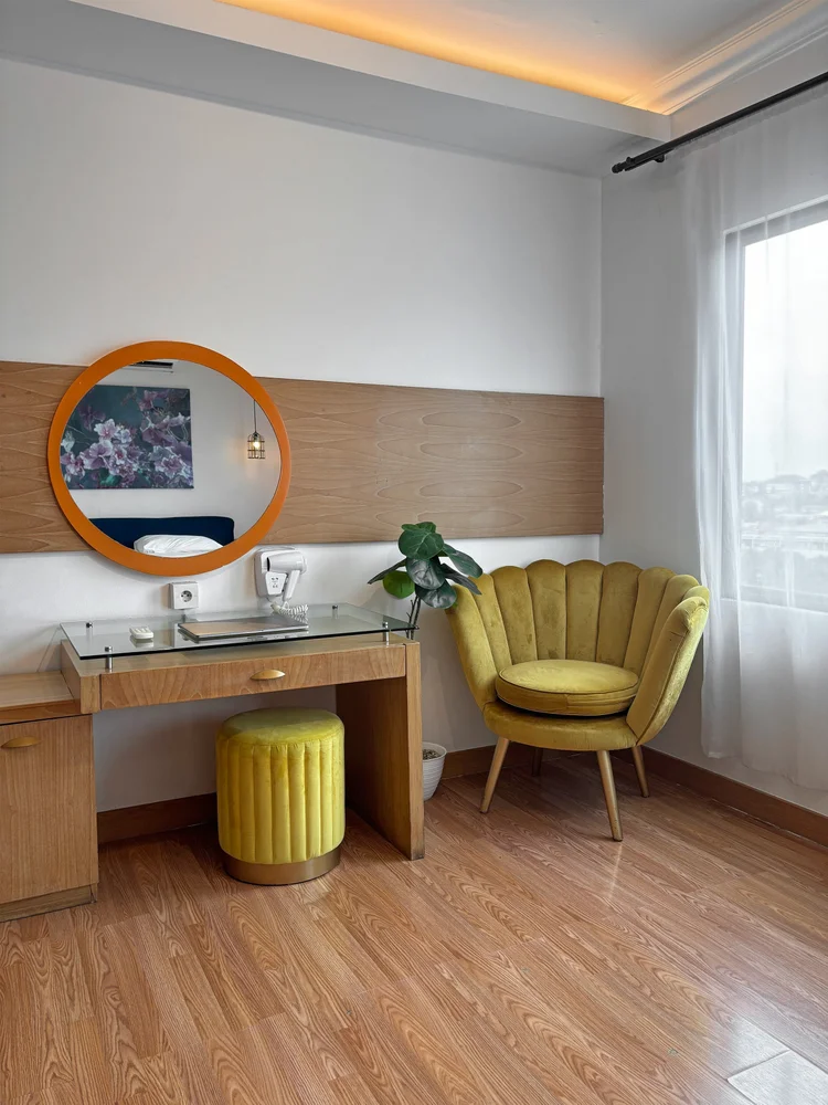 Beverly: Master bedroom: dressing table with a round mirror and an armchair to sit in.