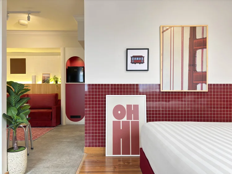 San Francisco: Golden Gate red tiles in the bed area, with a wall lamp and prints.