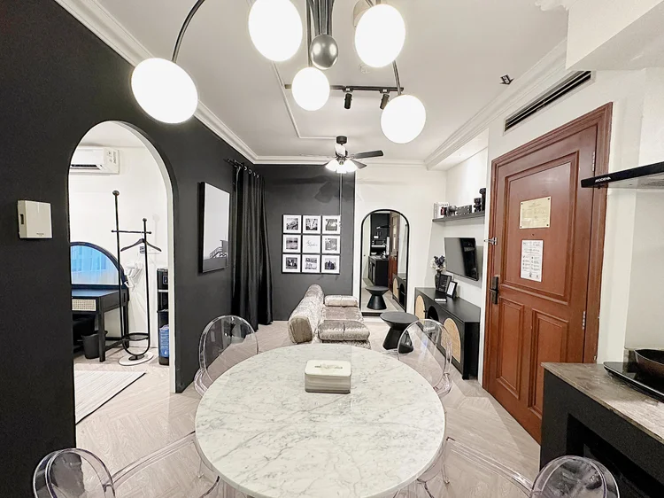 Los Angeles: A round dining table with clear chairs, under an archway that is a signature of this unit.