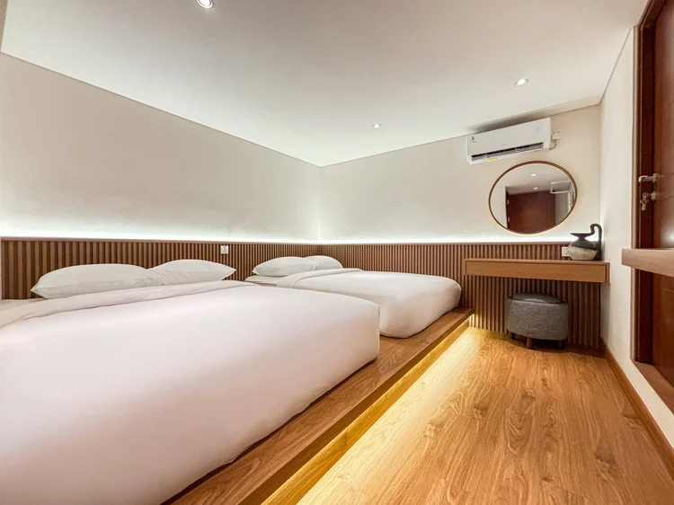 Shizuoka: A bedroom with a wide bed on a wooden platform, dressing table and its own AC.