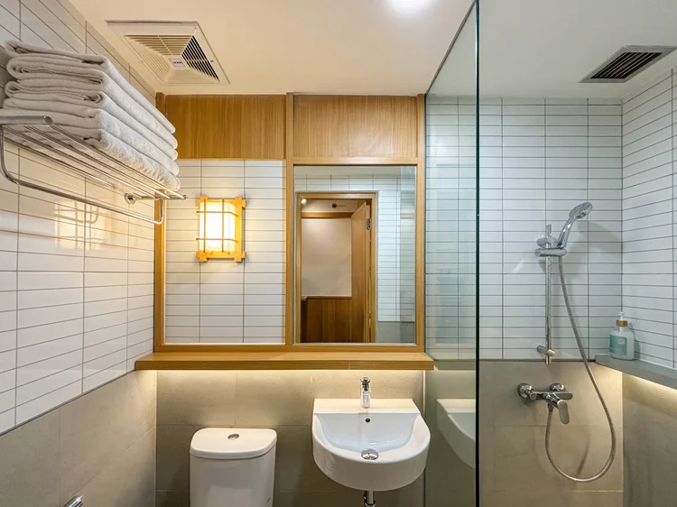 Omotesando: Modern bathroom with a glass-screened shower, clean towels for every guest.
