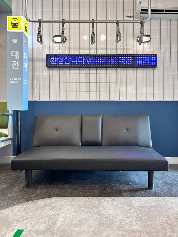 Dae Jeon: A subway handrail and a welcome sign above the sofa.