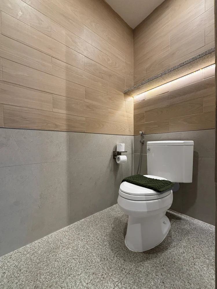 Okinawa: A sit-down toilet with tissue and a towel rail, small details still taken care of.
