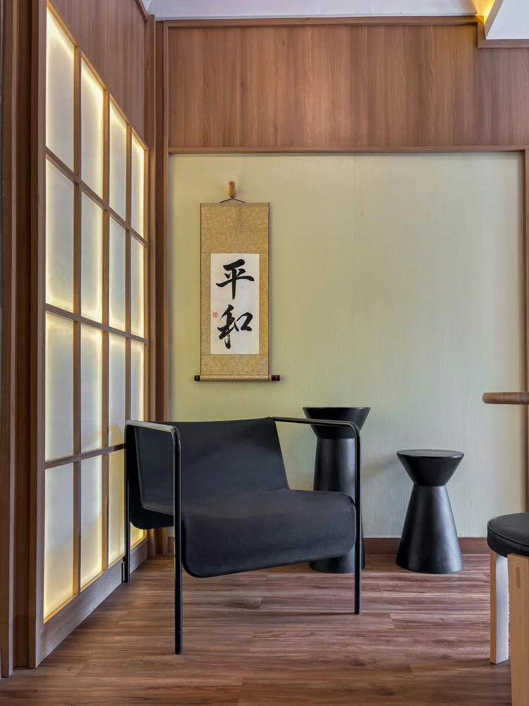 Sapporo: A corner armchair with a small table before the shoji panels and a calligraphy scroll.