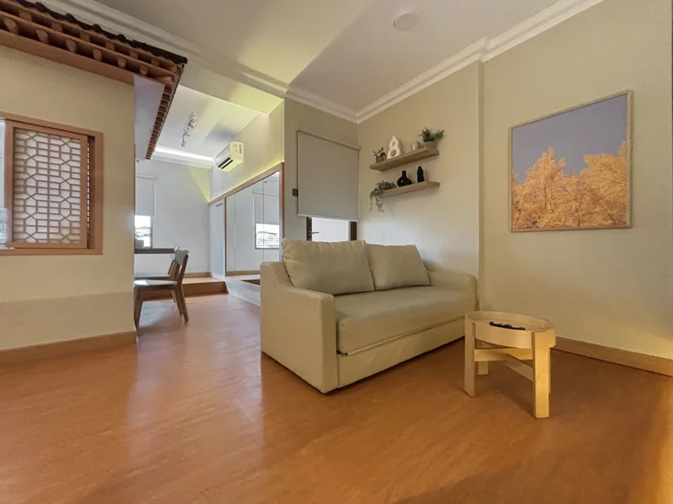 Nami: A cream sofa and a mini hanok roof, Korea inside the unit.