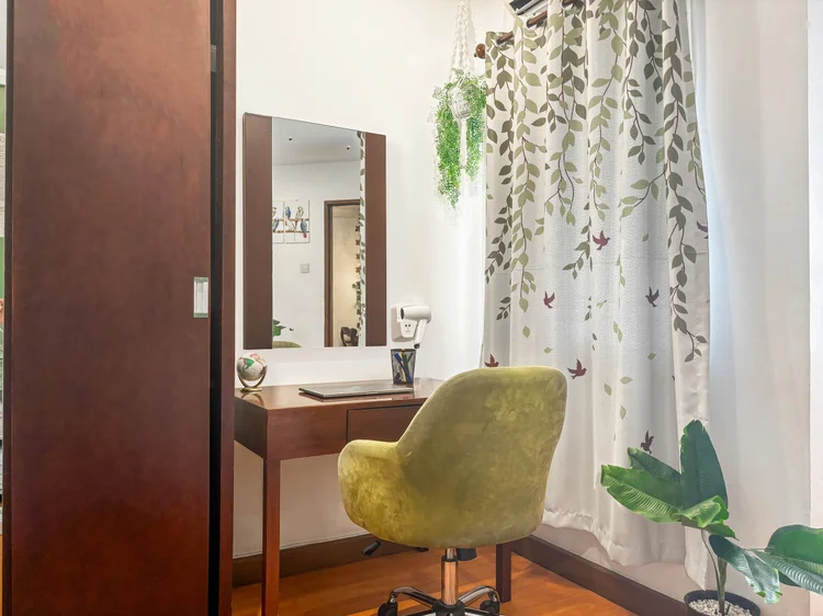 Tanzania: Dressing table and a sliding wardrobe in the master bedroom, with leaf-print curtains at the window.