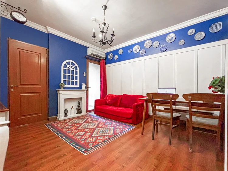 Amsterdam: Living room with the red sofa, dining table and its own AC, where everyone gathers.