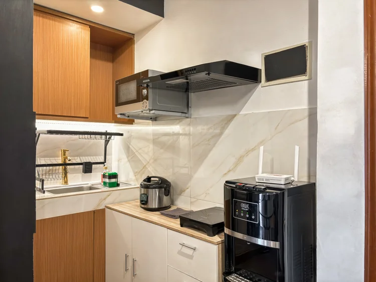 Vienna: Open kitchen with wood cabinets, a microwave and a sink; the basic cooking tools are all there.