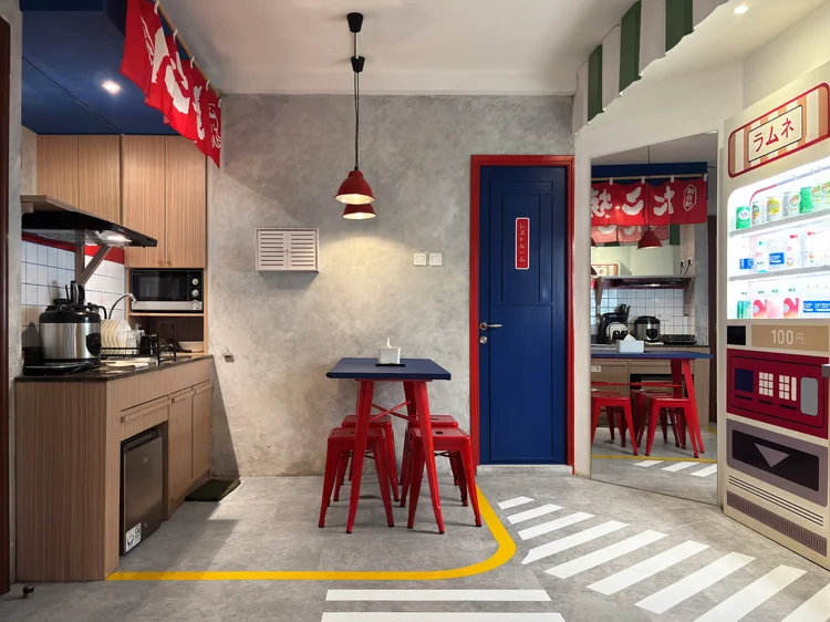 Shibuya: A dining table for four in front of the open kitchen, under the red noren.
