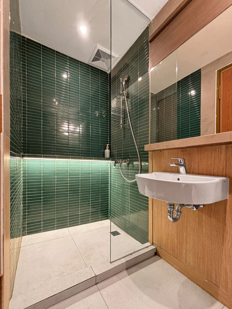 Aoyama: Modern bathroom with green tiles and a hot shower.