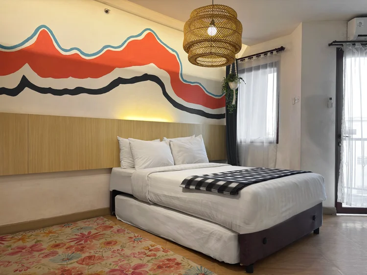 Barbados: A mountain mural above the bed, with a rattan lamp and patterned rug.