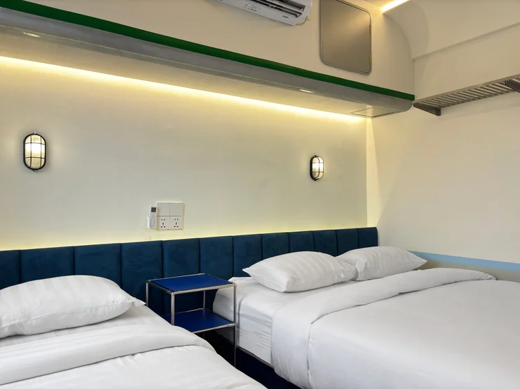 Dae Jeon: Bedroom with a queen bed and a single bed, white sheets the same standard in all our units.