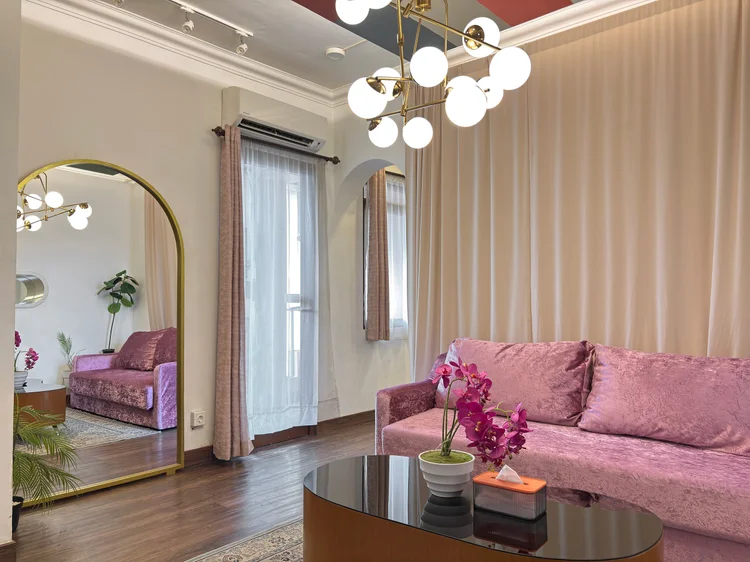 Beverly: Pink sofa and a gold arch mirror: Hollywood Art Deco in the living room.