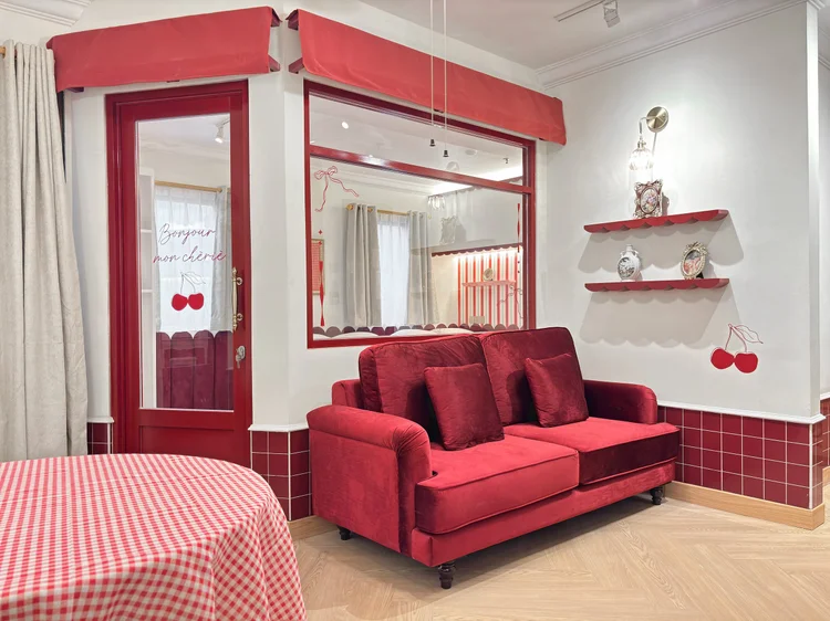 Chamonix: Living room with the red sofa and a small cherry-print shelf.