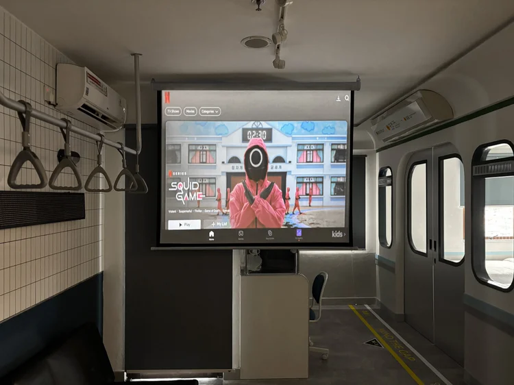 Dae Jeon: Smart projector with Netflix on a big screen, movie night cinema-style in the unit.