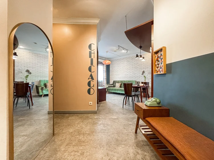 Chicago: An arch leads to the dining area, with a wood bench and dark blue wall.