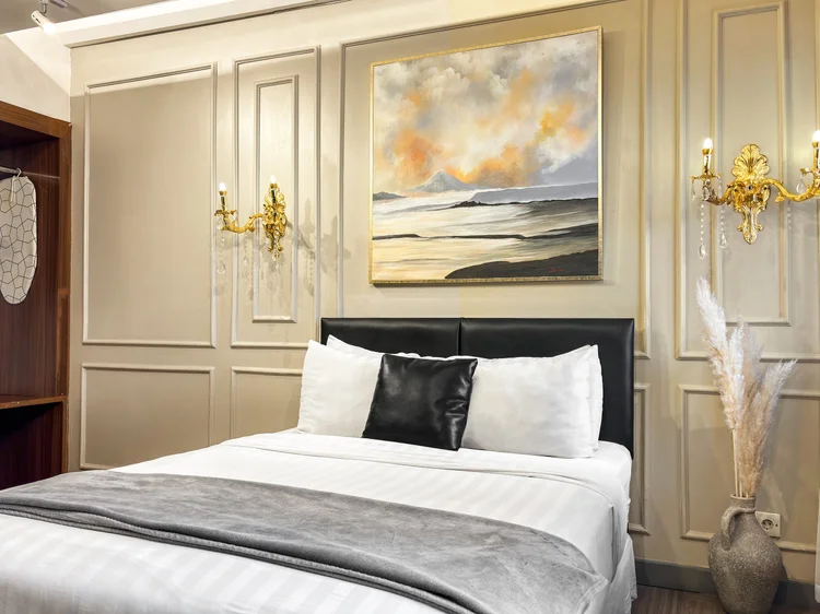 Vienna: An open wardrobe beside the bed, with gold sconces and dark curtains at the window.