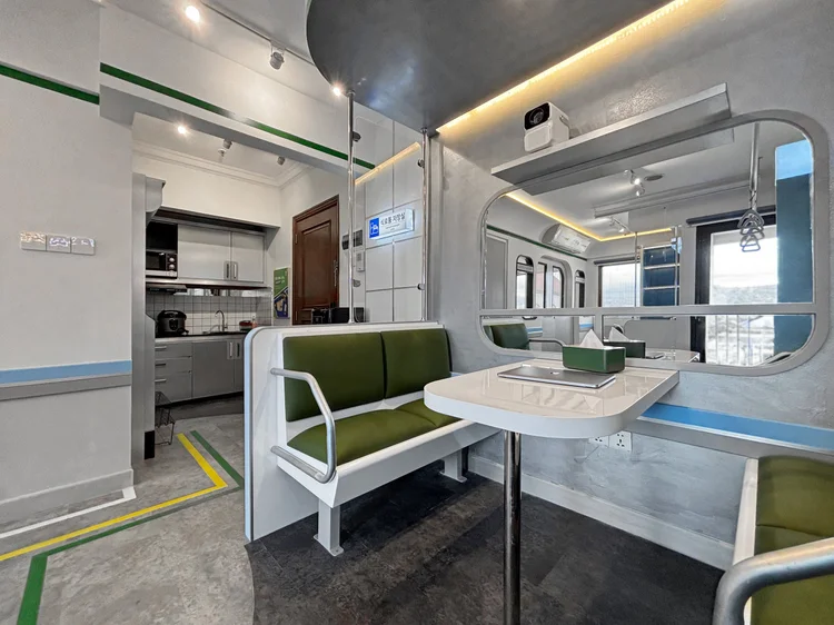 Dae Jeon: Train-style dining table with green bench seats, for meals together.