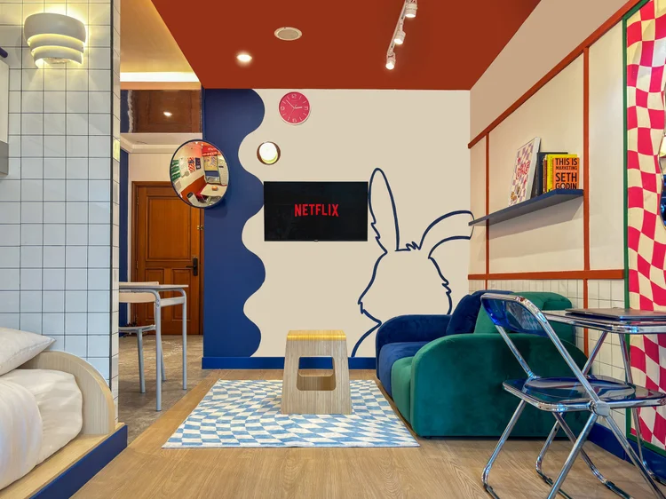 Hong Dae: The TV corner with the rabbit mural, where everyone gathers after a day out.